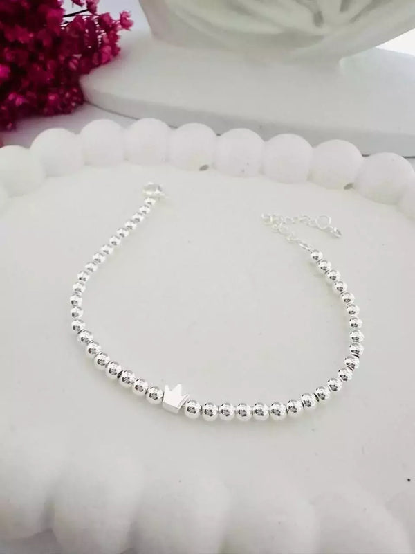 Pulseira Feminina Minimalista Bolinha com Pingente de Coroa em Metal Prateado – Serenité